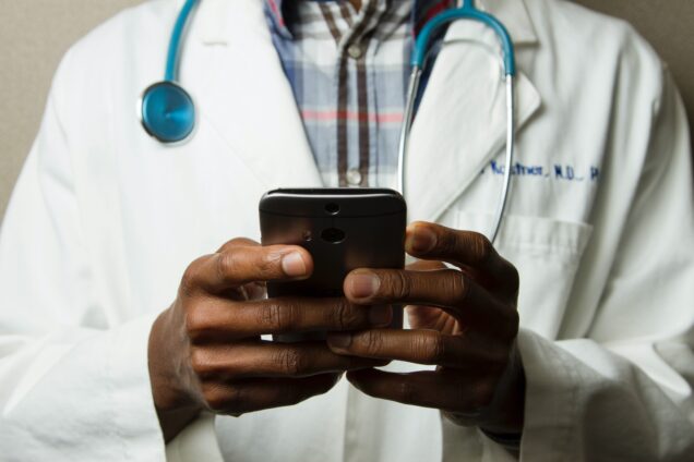 Closeup of a doctors hands using a cellphone