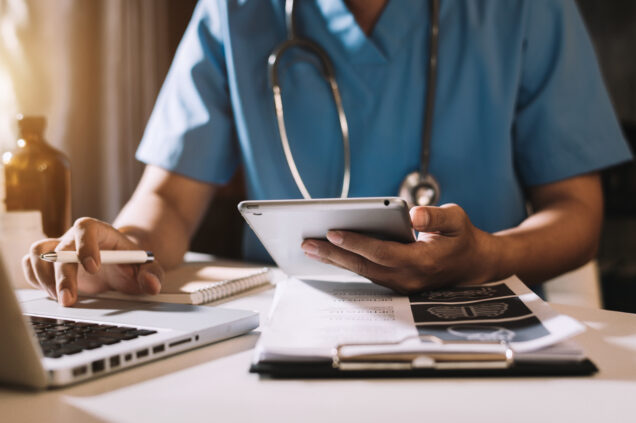 Medical technology concept. Doctor working with tablet and laptop.